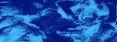 Bulanık kumaş, soyut yeşillikleri andıran zarif desenli canlı mavi gölgeler sergiliyor. Ayrıntılı dokuma tasarıma derinlik ve karmaşıklık ekler..