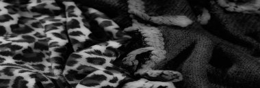 Karmaşık tasarlanmış kumaşların tek renkli görüntüsü kalın örgülü iplerle kalın hayvan izlerini birleştirerek dinamik ve sanatsal bir görsel doku yaratıyor..