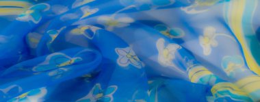 Göz kamaştırıcı bir kumaş, mavi renkler, çiçek desenleri ve sarı çizgilerin karışımı, dinamik renkler ve zarif kıvrımları mükemmel bir ahenkle birleştiriyor..