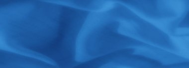 Görüntü yumuşak, akışkan mavi kumaş, yumuşak kıvrımlar ve yarı şeffaf bir doku. Madde, pürüzsüz hatları ve ışık etkileşimiyle huzur verici bir estetik yaratıyor..