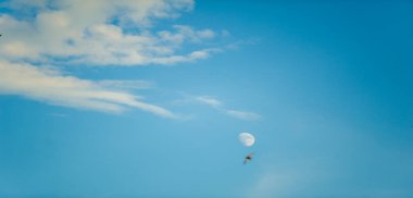 Parlak beyaz bulutların çarpıcı bir şekli berrak, derin bir mavi gökyüzüne karşı. Güneşten gelen ışık bulutların dokusunu ve şeklini güçlendirir ve dramatik bir etki yaratır..