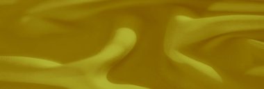 Yumuşak sarı kumaşlı, narin kıvrımlı ve pürüzsüz. Zengin altın sarısı renk ve karmaşık kumaş dokuması lüks ve soyut bir arkaplan yaratır..