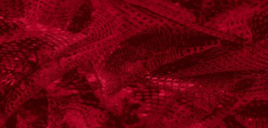 Bulanık, parlak ağ detaylarıyla dinamik kırmızı dantelli kumaş, zarif bir ışık etkileşimi ve karmaşık desenler oluşturur..