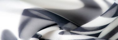 Görüntü, dalgalı siyah ve beyaz desenli akıcı kumaş. Yarı şeffaf doku ve dinamik tasarım zarif, soyut bir estetik yaratıyor..