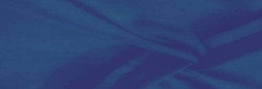 Mavi kumaş sergilerinin bulanık yakın çekimi yumuşak katlar ve akış çizgileri ile karışık dokular, görsel sanat projeleri için çağdaş ve rafine bir his sunuyor.