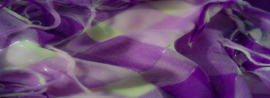 Bulanık odak noktası parlak mor ve beyaz kumaş, katmanlı dokular ve gevşek iplikler. Işığın ve gölgenin etkileşimi kumaşların karmaşık detaylarını vurgular.