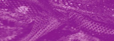 Bulanık - karmaşık desenleri ve yumuşak, akışkan dokuları olan zengin bir mor dantel kumaş. Görüntü, yumuşak kıvrımlar ve narin dokumalarla kumaşın zarafetini vurgular..