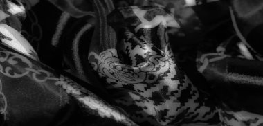Bulanık - yumuşak, siyah ve beyaz kumaş, houndstooth ve dekoratif çiçek zinciri desenlerinin kombinasyonu. İpeksi bir parıltı ve karmaşık bir detay yakalar.