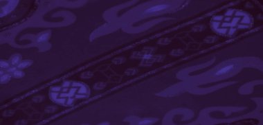 Görüntü. Klasik ve çağdaş estetiğin bir karışımını sunan simetrik çiçek ve geometrik tasarımlı koyu mor bir kumaş..