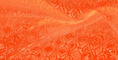 Geometrik desenleri ve pürüzsüz dokuları olan turuncu kumaşın soyut bir görüntüsü. Kumaşın kabartmalı elementleri derinlik yaratır ve yumuşaklığıyla çelişen görsel dinamik bir etki yaratır.
