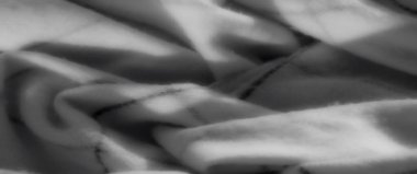 Doğrusal desenli gri pullu kumaşın bulanık yumuşak kıvrımları pürüzsüz ve zarif yapısını vurgulayarak doku ve gölgelerin etkileşimini oluşturur..