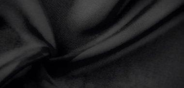 Bulanık siyah kumaş, yumuşak kıvrımlar ve kadife gibi bir doku. Nazik ışıklandırma, doğal perdeleri ön plana çıkarır ve lüks ve incelik hissi katar..