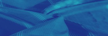 Mavi kumaşın bulanık görüntüsü karmaşık çiçek motifleri ve üst üste binen çizgili desenler dekoratif amaçlar için yumuşak ve katmanlı bir görsel cazibe yayıyor..