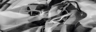 Yumuşak yıpranmış siyah ve beyaz kumaş iplikçiklerinin bulanık görüntüsü, materyalin karmaşık dokumasının ince detaylarına odaklanıyor..