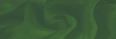 Hassas kırışıklıkları olan, akan yeşil kumaş bulanıklığı. Yumuşaklık ve doku birleşerek bu soyut tasarımda bir ahenk ve lüks hissi yaratır..