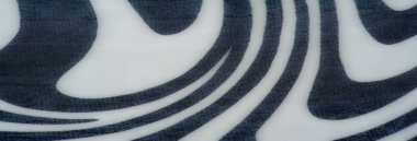 Bulanık gri tonlu, koyu siyah ve beyaz soyut dalga benzeri desenleri olan bir kumaş. Yumuşak kıvrımlar ve pürüzsüz doku dinamik ama sakin bir görsel etki yaratır..