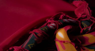 Görüntü - Dekoratif kırmızı kumaş çiçekli ve geometrik desenli parlak aksanlı bir karışım içerir, gelenek ve çağdaş stil arasında mükemmel bir denge sunar.