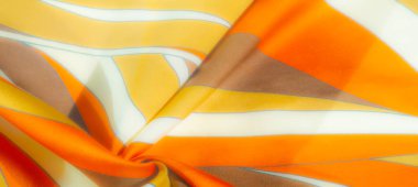 Işıl ışıl turuncu, sarı ve kahverengi tonlu, çizgili desenli bulanık kumaş. Pürüzsüz kıvrımlar ve saten dokular resme yumuşak, zengin bir görünüm verir.