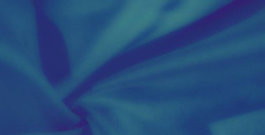 Görüntü. Yumuşak ve akışkan kıvrımlı bir kumaş, koyu mavi tonlara sahip. Doku pürüzsüz gölgelerle vurgulanır ve görsel olarak rahatlatıcı bir kompozisyon yaratır..