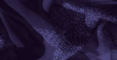 Görüntü. Karmaşık desenleri ve ince kıvrımları olan mor bir kumaş. Çiçeklerden esinlenilmiş tasarım ve pürüzsüz dokular lüks hissi artırıyor. İnce ve soyut bir Visua yaratıyor.