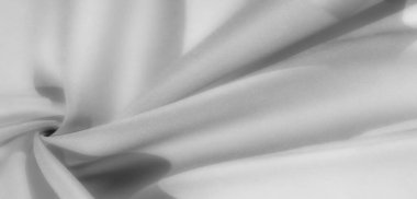 Yumuşak kıvrımları ve pürüzsüz dokusu olan gri ölçekli bir kumaşın bulanık görüntüsü, rahatlatıcı ve minimalist bir estetik yaratıyor, modern tasarım ve yaratıcı projeler için mükemmel..