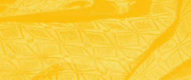 Kabartmalı yaprak detaylarıyla kalın sarı kumaş, dinamik bir doku ve lüks bir his sunuyor..