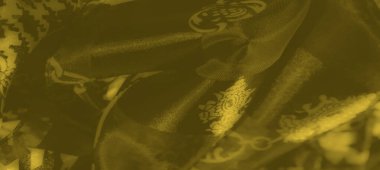 Bulanık sarı kumaş, dinamik bir düzende zincir benzeri şekiller ve soyut desenler sergiliyor. Yansıtıcı bir dokuya sahip lüks ve zarafet yayıyor..