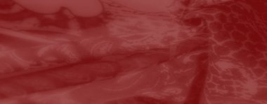 Çiçek desenleri ve desenlerle süslenmiş bulanık kırmızı kumaş. Zengin doku ve sanatsal detaylar çeşitli tasarımlar için zamansız, zarif bir estetik yaratır..