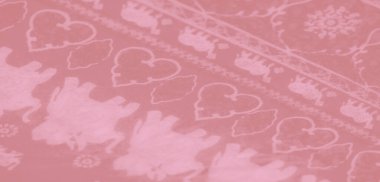 Bulanık, karmaşık beyaz fil motifleri olan yumuşak pembe bir kumaş zarif bir şekilde kıvrılarak, dokulu bir görünüm ve lüks bir estetik yaratıyor..