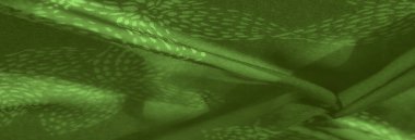 Bulanık, organik yeşil kumaş ve yapraktan esinlenilmiş desenler, canlı ve yumuşak bir estetik yaratıyor. Nazik kıvrımlar ve katmanlı dokular genel görsel ahenge eklenir.