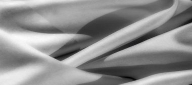 Görüntü - Akan kıvrımları ve kıvrımları olan dokulu bir kumaşın detaylı gri tonlu fotoğrafı. Bileşimi entelektüellik ve dingin bir zarafet yayıyor..