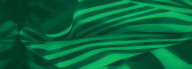 Görüntü. Yeşil kumaş siyah çizgili desenlere sahip, pürüzsüz kıvrımlarıyla canlı bir görsel etki yaratıyor. Soyut tasarım modern ve yaratıcı bir estetik yayar..