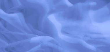 Yumuşak dokuları ve dinamik akış şekilleri olan soyut mavi kumaş bulanıklığı, yaratıcı tasarımlar ve sakinleştirici arka planlarda kullanmak için zarafet ve basitliği birleştirmek