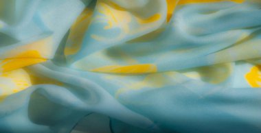 Açık mavi ve sarı renkli, soyut desenleri olan bulanık bir yakın çekim. Yaratıcı tasarımlar için mükemmel, akıcı ve hafif bir doku sergiliyor.