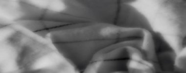 Bulanık desenli gri kumaş perdeler. Detaylı kıvrımlar ve yumuşak doğrusal aksanlarla modern ve sofistike bir dokunuş ekliyor..