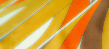 Pürüzsüz kıvrımlı, turuncu, sarı ve kahverengi kumaşlı. Canlı, sıcak renkler büyüleyici bir enerjiyle modern, şık bir tekstil deseni yaratır.