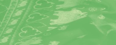 Nazik, yeşil bir kumaşın bulanık görüntüsü, ince, beyaz çiçek desenli, yumuşak ve huzurlu bir görünüm yaratıyor. Kumaşın kıvrımları ve zarif deseni onu giysi ve dekor için ideal hale getiriyor.,