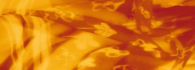 Hafif turuncu kumaştan bulanık çiçek desenleriyle süslenmiş, pürüzsüz katmanlar halinde akan. Yumuşak, ruhani tasarım çekiciliğini ve çok yönlülüğünü vurguluyor..