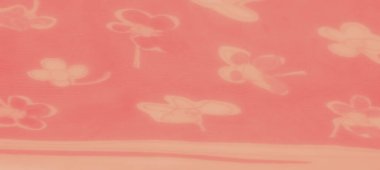 Yumuşak katlı ve şeffaf katmanlı soyut çiçek desenleri içeren canlı turuncu bir kumaş sıcak ve dinamik bir doku yaratıyor. Kumaşın ayrıntıları sanatsal bir akışı gösteriyor