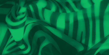 Çizgili yeşil kumaş bulanıklığı kalın kıvrımlı çizgiler ve gölgeli kırışıklıklar gösteriyor. Dinamik hareket ve akış ile çarpıcı bir soyut tasarım sunuyor..
