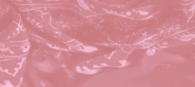 Zarif çiçek ve fil motifleriyle pembe kumaşın bulanık görüntüsü, kumaşın karmaşık tasarımı ve lüks dokusunu vurgulamak için pürüzsüz kıvrımlar halinde dönüyor..