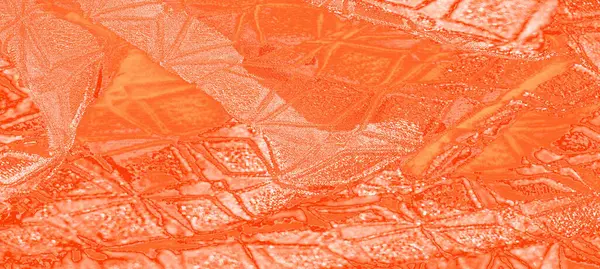 Geometrik desenleri ve pürüzsüz dokuları olan turuncu kumaşın soyut bir görüntüsü. Kumaşın kabartmalı elementleri derinlik yaratır ve yumuşaklığıyla çelişen görsel dinamik bir etki yaratır.