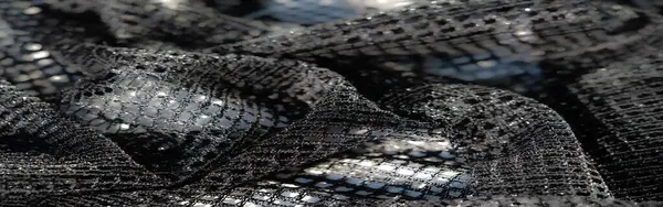 Hassas siyah dantelli kumaşın bulanıklığı ince ayrıntıları yansıtan karmaşık ağ desenleri. Yumuşak kıvrımlar ve parıldayan detaylar büyüleyici bir doku yaratır..