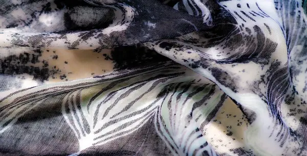 Görüntü, zarif bir tekstil siyah ve yumuşak soluk renkleri karmaşık desenlerle birleştirir. Akan kumaş zamansız ve sanatsal bir özü yakalar..