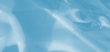 Yumuşak mavi kumaştan bulanık, zarif katmanlı ve yıpranmış ipliklerle dokunmuş, soyut ve zarif bir kompozisyon oluşturarak dokuyu ve ışığı vurguluyor..