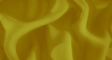 Karmaşık kıvrımları ve ince kıvrımları olan altın sarısı kumaş bulanıklığı. Pürüzsüz dokusu ve lüks parıltısı dinamik ve zarif bir tekstil görüntüsü yaratır.