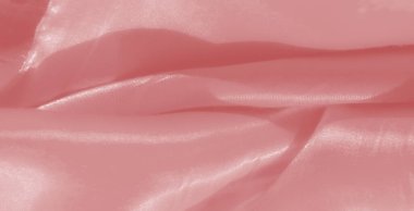 Pürüzsüz, saten bir dokusu ve akışkan kıvrımları olan bulanık pembe kumaş, zarif röfleler ve lüks tasarımlar için zarif bir ortam yaratıyor..