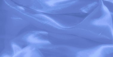 Görüntü. Parlak açık mavi saten kumaş. Sıvı perdeleri ve yumuşak kıvrımları var. Zarif ve sofistike bir estetik yaratmak için ışığı zarifçe yansıtıyor..