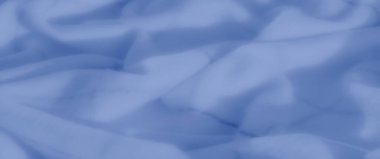 Yumuşak geçişler ve soyut dalgalanmalarla mavi kumaşın bulanık görüntüsü. Dokulu yüzey ve gölge oyunu derinlik ekler, modern ve rahatlatıcı arka planlar için idealdir.