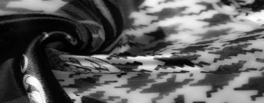 Görüntü, çarpıcı bir kontrastla aydınlatılmış saten benzeri kumaşı gözler önüne seriyor. Zarif çiçek ve zincir esinlenilmiş motifler, sofistike ve sanatsal görünüm yayıyor..